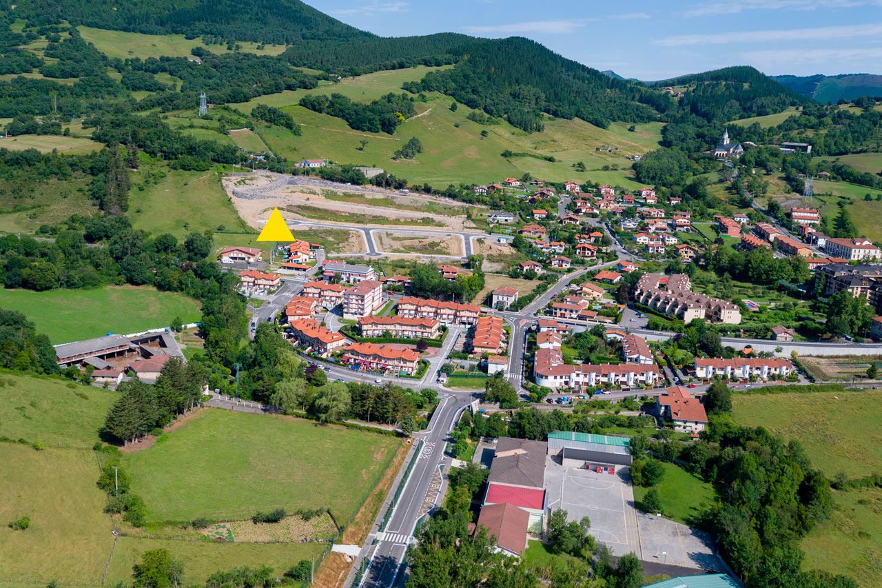 Hormazaren eremuaren aireko ikuspegia, urbanizatzeko lursailarekin eta ondoko etxebizitzekin.